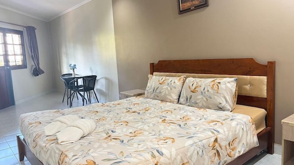 A bedroom with a bed, a desk, and a chair.