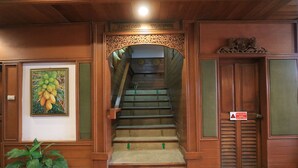 Un escalier en bois avec une signalisation indiquant une sortie de secours en cas d’incendie.
