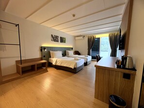 A hotel room with two beds, a wooden bench, a small table, and a trash bin. - Wyndham Garden Shahzan Fraser's Hill (Raub)