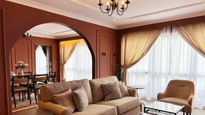 Un salon élégant, doté d’un canapé, de fauteuils, d’une table basse et d’un coin repas avec des chaises et une table.