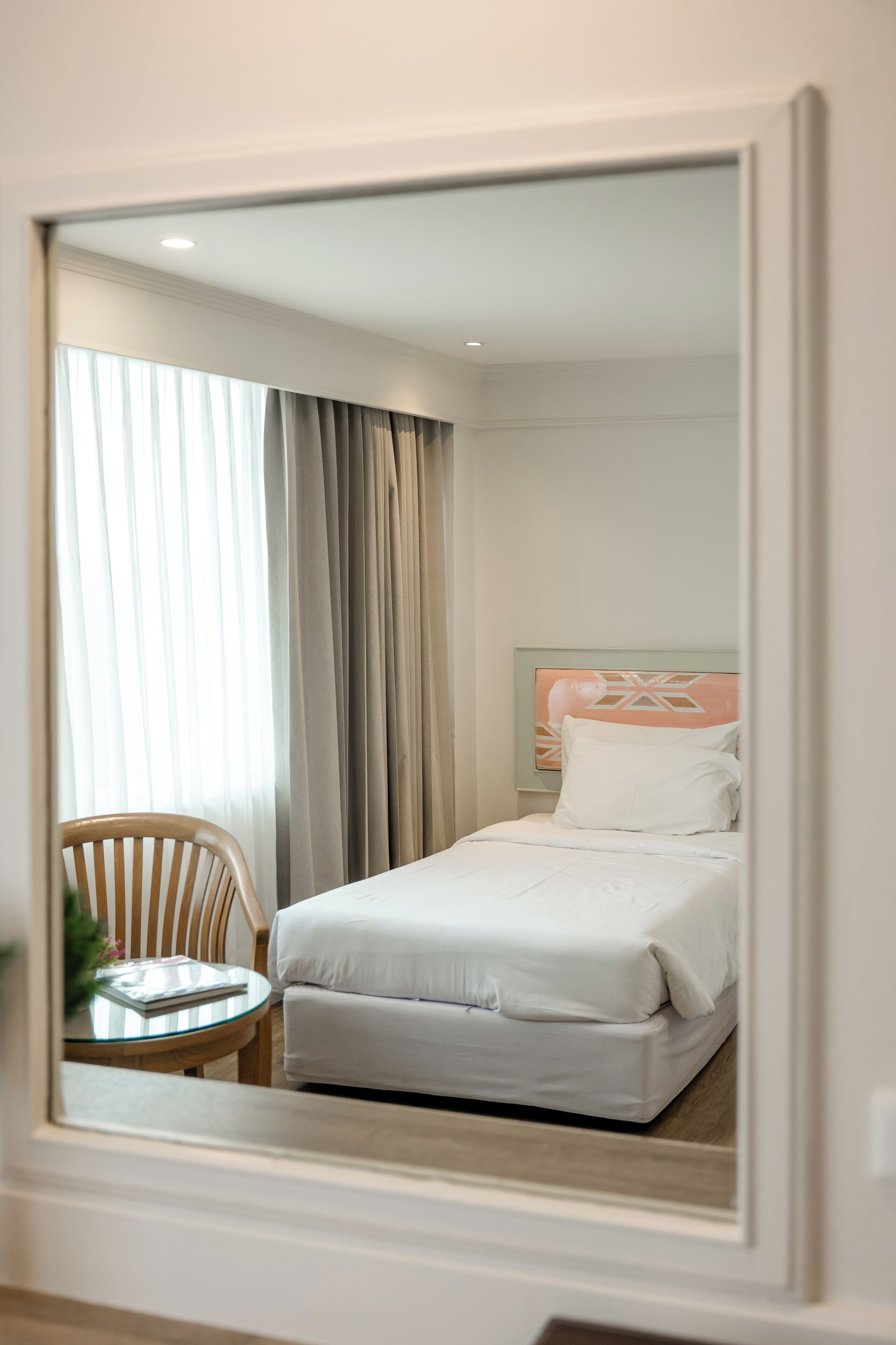 A hotel room with a bed, a chair, and a table.