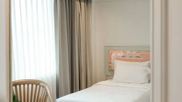 A hotel room with a bed, a chair, and a table.