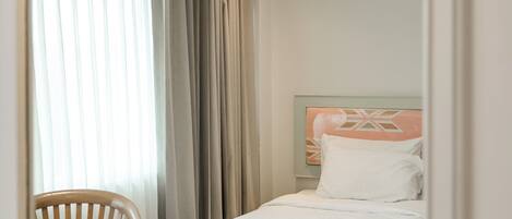 A hotel room with a bed, a chair, and a table.
