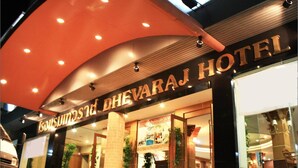 The exterior of the Sarvajjan Hotel with a prominent entrance and a large overhang. - Dhevaraj Hotel (Nan)