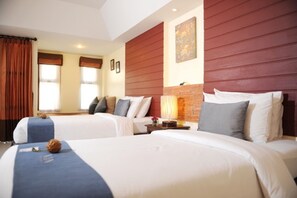 Une chambre d’hôtel avec deux lits, un mur décoratif en briques et une grande fenêtre avec des rideaux.