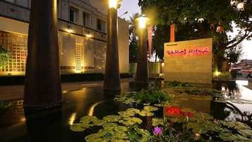 A nighttime view of a hotel entrance with a sign reading "Toksams Hotel".