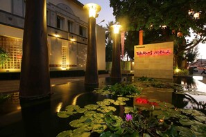 A nighttime view of a hotel entrance with a sign reading "Toksams Hotel". - Tohsang City (Ubon Ratchathani)