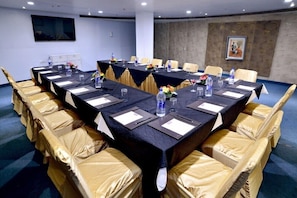 A conference room with a long table, chairs, and water bottles. - The Theme Jaipur (Jaipur)