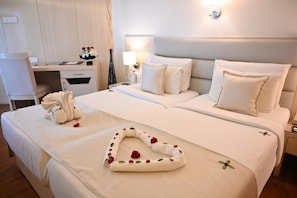 A hotel room with a neatly made bed, a desk, and a chair.