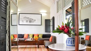 A living room with a sofa, coffee table, and a vase with flowers. - Muntri Mews (George Town)