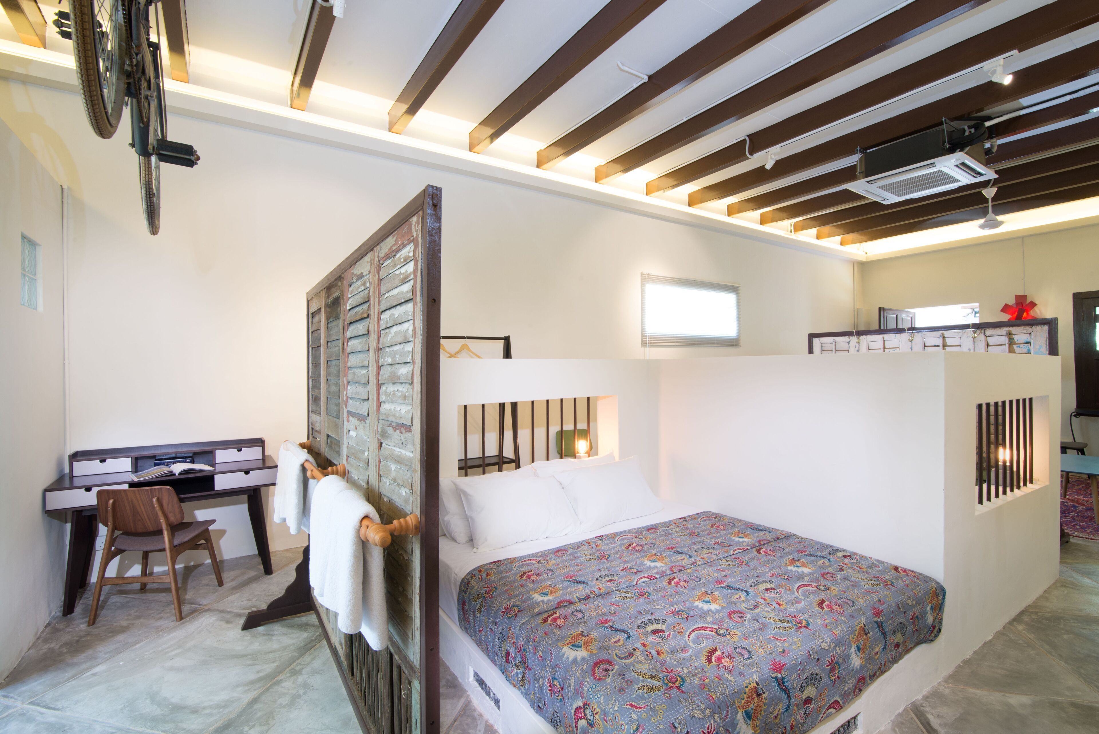 Un dormitorio con cama, escritorio y silla.
