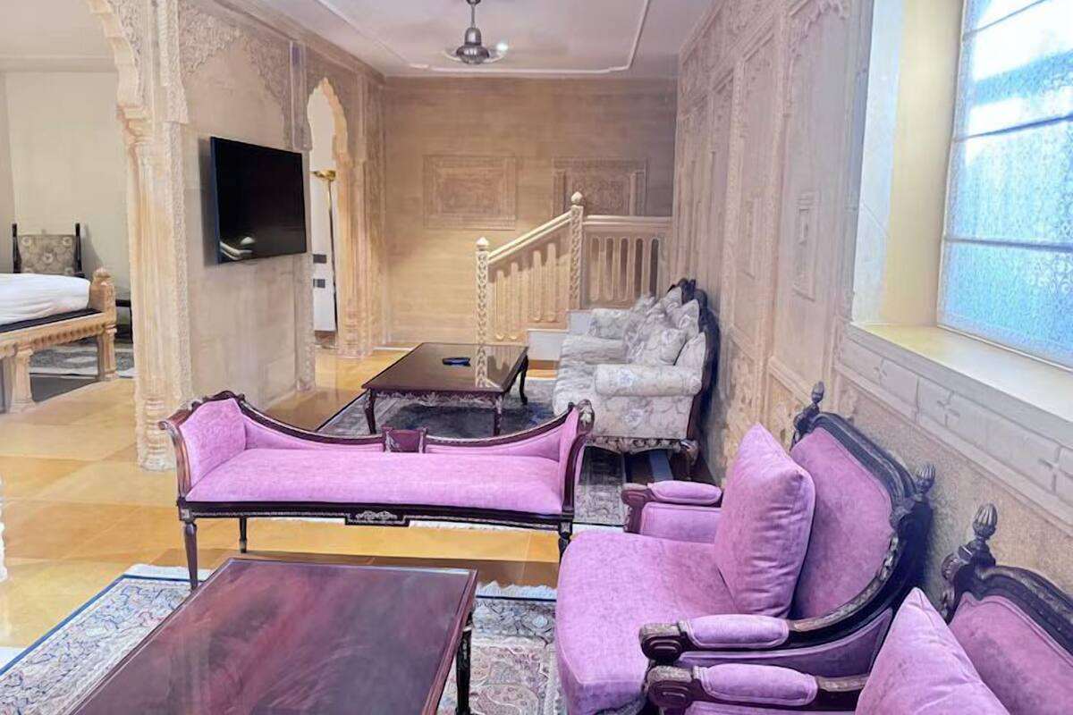 A room with a bed, a sofa, a coffee table, and a TV.