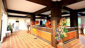 A reception area with a check-in counter, large pillars, and potted plants. - Supsangdao Resort (Krabi)
