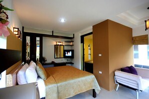 A hotel room with a bed, a sofa, a television, and a bathroom. - Supsangdao Resort (Krabi)