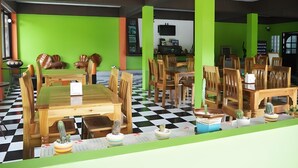 A restaurant with wooden tables and chairs, green walls, and a checkered floor. - Supsangdao Resort (Krabi)