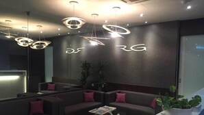 A modern reception area with a sectional sofa, a coffee table, and pendant lighting. - The Regency Garden Hotel (Ipoh)