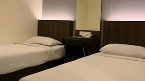 A hotel room with two single beds, a desk with a chair, and a telephone. - The Regency Garden Hotel (Ipoh)