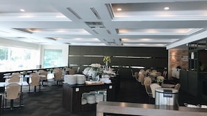 Un moderno vestíbulo de hotel con un mostrador de recepción central, varias zonas de estar y grandes ventanales que proporcionan luz natural.