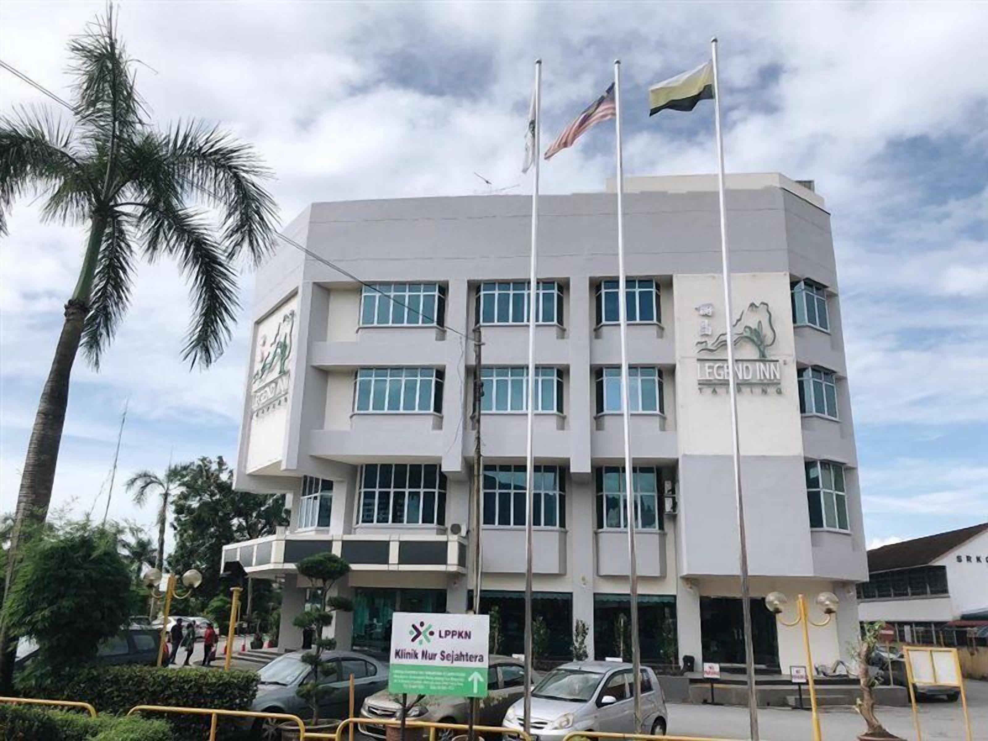 A multi-story building with a sign for 'LEGION INN' and flags on top.