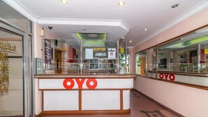 A reception area with a glass partition, a reception desk, and a sign that reads "RECEPTION". - Holiday Park (KOTA KINABALU)