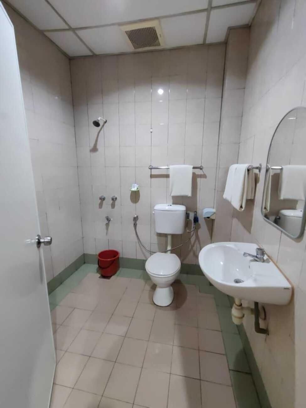 A bathroom with a toilet, sink, and shower.