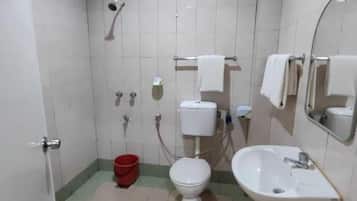 A bathroom with a toilet, sink, and shower.