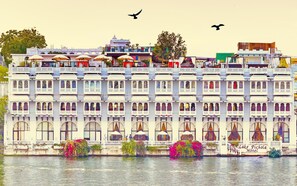 A multi-story building with balconies, a sign reading "Lake Pichola Hotel," and a body of water in front. - Lake Pichola (Udaipur)