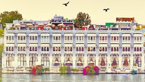 A multi-story building with balconies, a sign reading "Lake Pichola Hotel," and a body of water in front. - Lake Pichola (Udaipur)