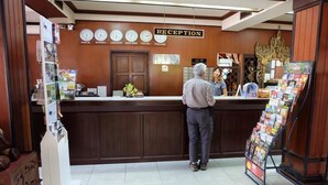 A reception area with a wooden counter, clocks displaying times in Paris, Sydney, London, New York, Tokyo, and Thailand, and a sign reading "RECEPTION". - Prince (Chiang Mai)