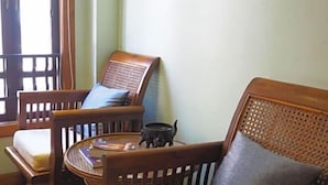 Una habitación tradicional de madera con un sofá, dos sillones y una mesita.