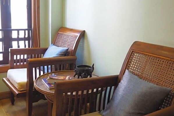 Una habitación tradicional de madera con un sofá, dos sillones y una mesita.