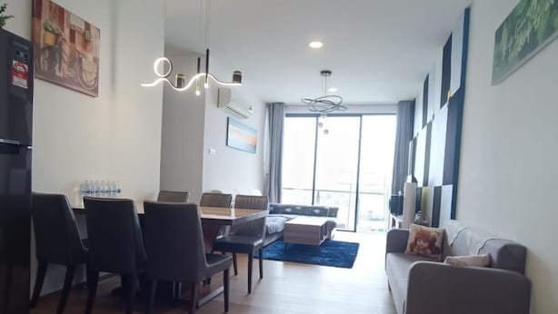 Una sala moderna con comedor, sofá y televisor.