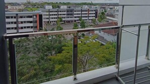 Vista desde un balcón sobre un estacionamiento y un complejo de edificios de varios pisos con un letrero con la letra 'B'.