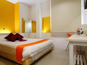 A modern bedroom with a bed, bedside table, and a mirror. - Mega Inn (Kuching)