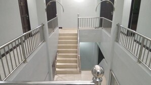 Una escalera con barandillas de metal y pasamanos, que lleva a un piso superior.