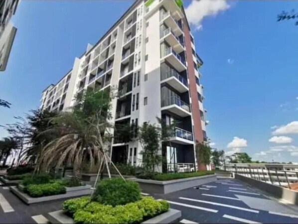 A modern multi-story residential building with balconies, surrounded by well-maintained greenery and a clear sky. - Mega Inn (Kuching)