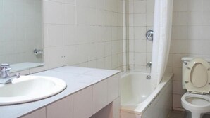 Un baño con lavabo, inodoro, bañera y cortina de ducha.