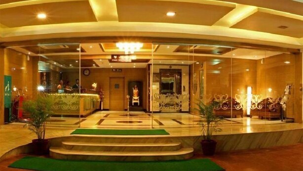 A hotel lobby with a curved ceiling, a central chandelier, and a reception desk. - Clinton Park Inn (Nagapattinam)