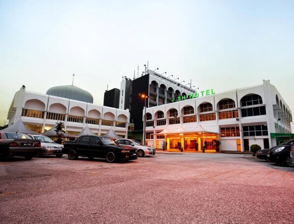 Experience the TH Hotel's sleek, modern design, featuring a symmetrical facade and arched windows.
