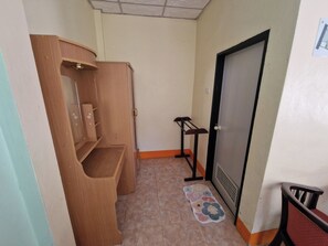 A small, narrow hallway with a wooden cabinet, a door, and a chair. - Rim Khao Jungle Resort Koh Lanta (Ko Lanta)