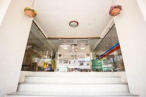 Escales que condueixen a una zona comercial amb portes de vidre i cistells penjants.