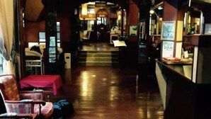A hotel lobby with a wooden floor, a reception desk, and several chairs. - Shari-La Island Resort (Teluk Aur)