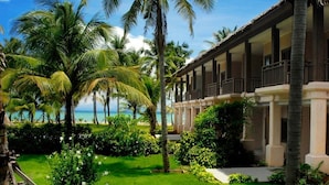 Un resort con piscina, palmeras y vista al océano.