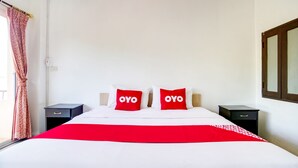 Ein Hotelzimmer mit einem großen Bett, zwei Nachttischen und einem Fenster mit Vorhängen.