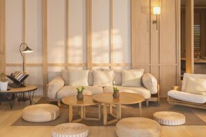A modern living room with a sofa set, two coffee tables, and a side table with a lamp. - Amphawa Nanon Hotel (Amphawa)