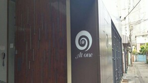 A building facade with a logo that reads "At one" and a spiral symbol. - At One (Bangkok)