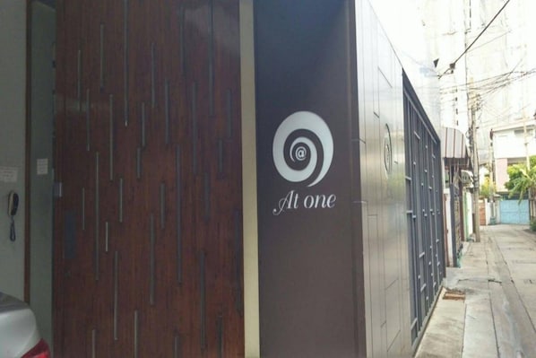 A building facade with a logo that reads "At one" and a spiral symbol. - At One (Bangkok)