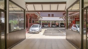 Zona d'aparcament de cotxes amb diversos vehicles i una màquina expenedora de Coca-Cola.
