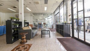 Un vestíbul amb un sofà, una taula de cafè i prestatges amb plantes.