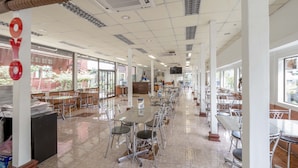 Una àmplia zona de dinar a l'interior, amb sostres alts, grans finestres i un paviment de rajoles.